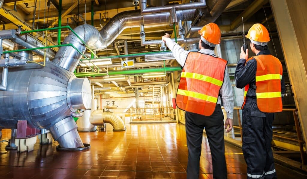 a man in a hard hat pointing at a machine