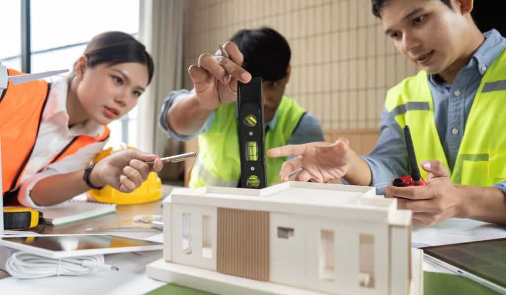 a group of people looking at a model of a house