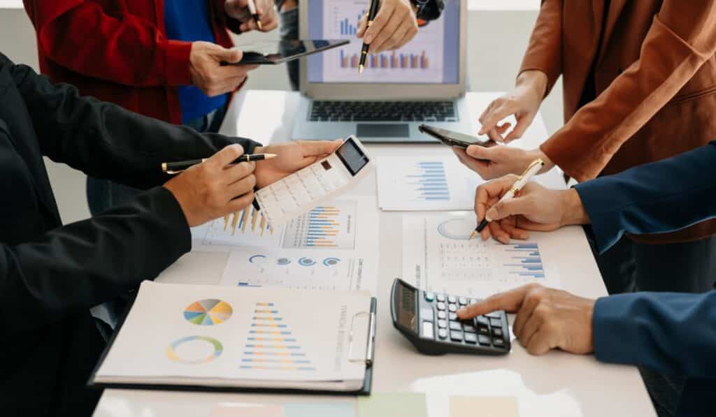 a group of people holding pens and calculators