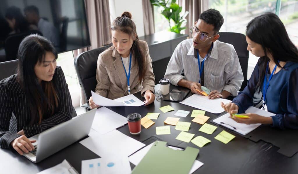 a group of people sitting around a table with sticky notes